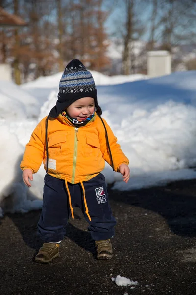 Küçük çocuk karda gülümser ve oynar. Yüksek kalite fotoğraf