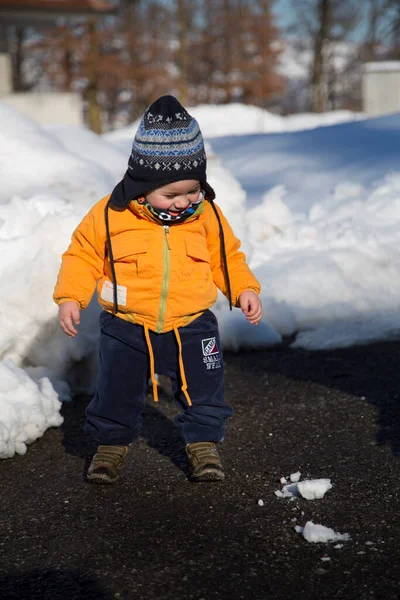 Küçük çocuk karda gülümser ve oynar. Yüksek kalite fotoğraf