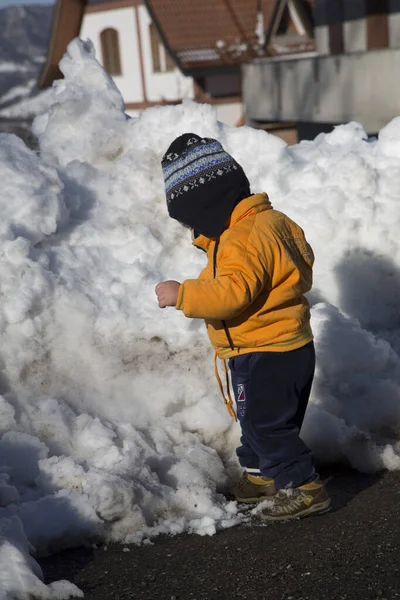 Küçük çocuk karda gülümser ve oynar. Yüksek kalite fotoğraf