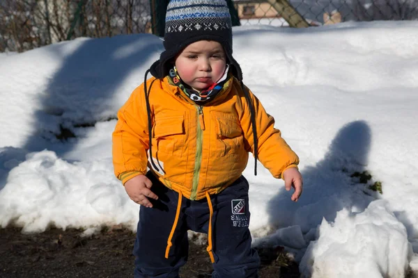 Küçük çocuk karda gülümser ve oynar. Yüksek kalite fotoğraf