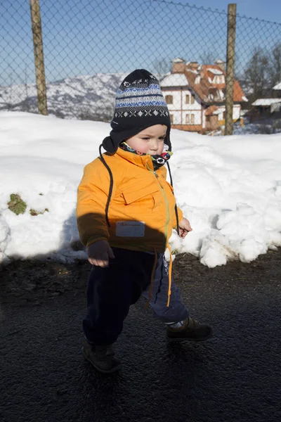 Küçük çocuk karda gülümser ve oynar. Yüksek kalite fotoğraf