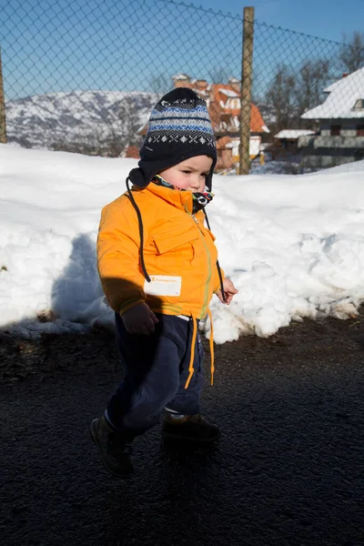 Küçük çocuk karda gülümser ve oynar. Yüksek kalite fotoğraf