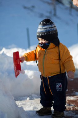 Küçük çocuk karda gülümser ve oynar. Yüksek kalite fotoğraf