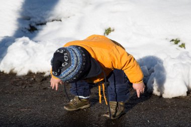 Küçük çocuk karda gülümser ve oynar. Yüksek kalite fotoğraf