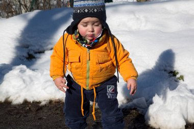 Küçük çocuk karda gülümser ve oynar. Yüksek kalite fotoğraf