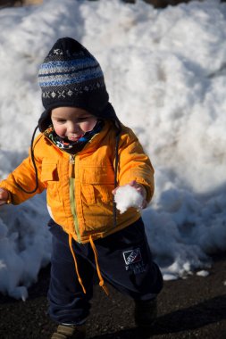 Küçük çocuk karda gülümser ve oynar. Yüksek kalite fotoğraf