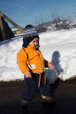 Küçük çocuk karda gülümser ve oynar. Yüksek kalite fotoğraf