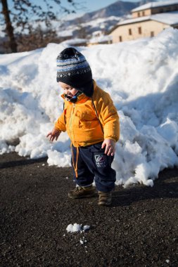 Küçük çocuk karda gülümser ve oynar. Yüksek kalite fotoğraf