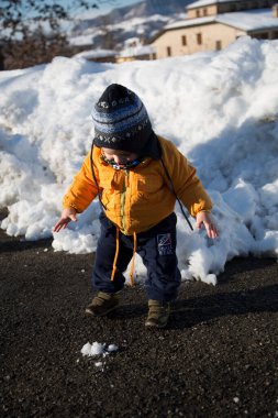 small child smiles and plays in the snow. High quality photo