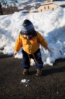 Küçük çocuk karda gülümser ve oynar. Yüksek kalite fotoğraf