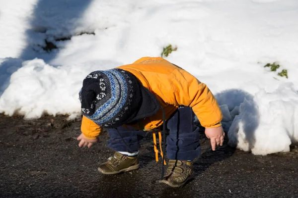 Küçük çocuk karda gülümser ve oynar. Yüksek kalite fotoğraf