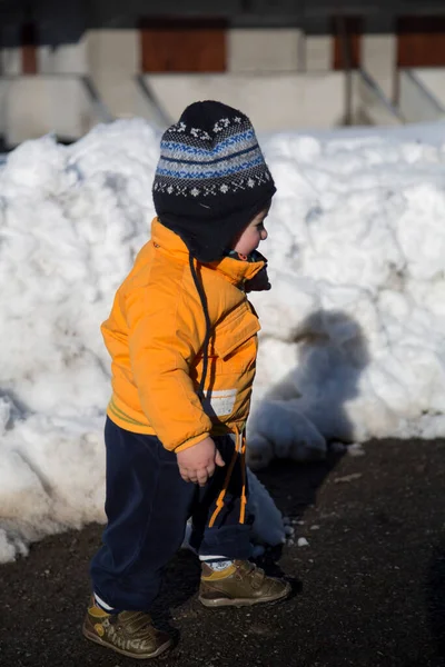 Küçük çocuk karda gülümser ve oynar. Yüksek kalite fotoğraf