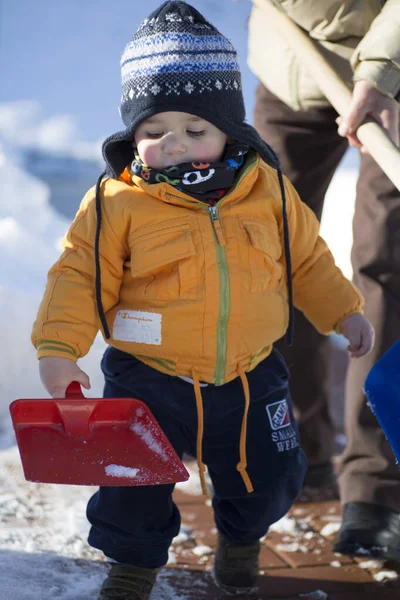 Küçük çocuk karda gülümser ve oynar. Yüksek kalite fotoğraf
