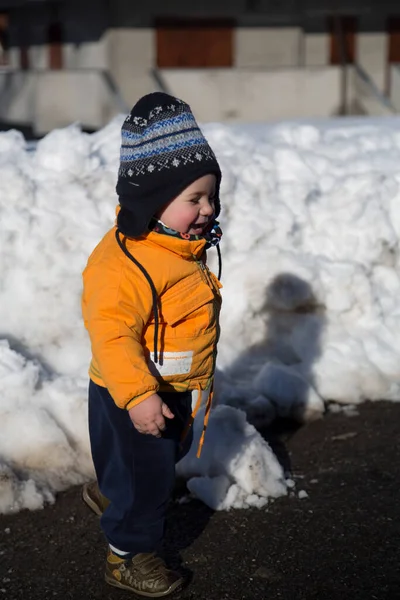 Küçük çocuk karda gülümser ve oynar. Yüksek kalite fotoğraf