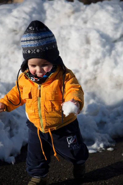 Küçük çocuk karda gülümser ve oynar. Yüksek kalite fotoğraf