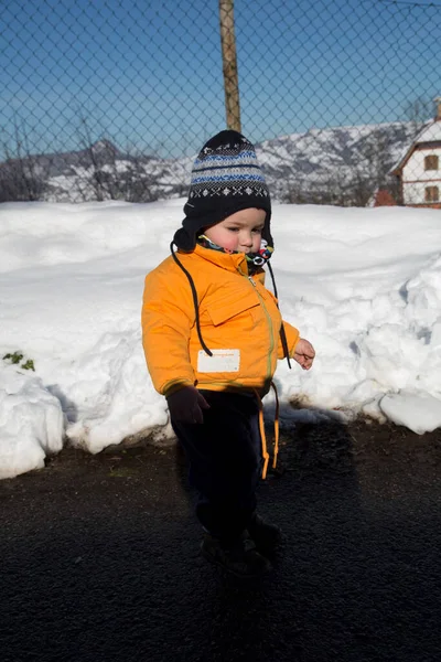 Küçük çocuk karda gülümser ve oynar. Yüksek kalite fotoğraf