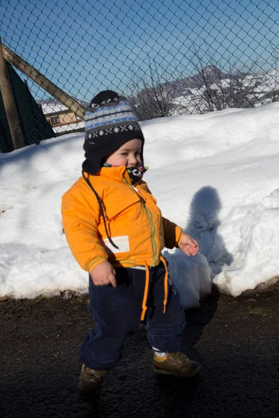 Küçük çocuk karda gülümser ve oynar. Yüksek kalite fotoğraf