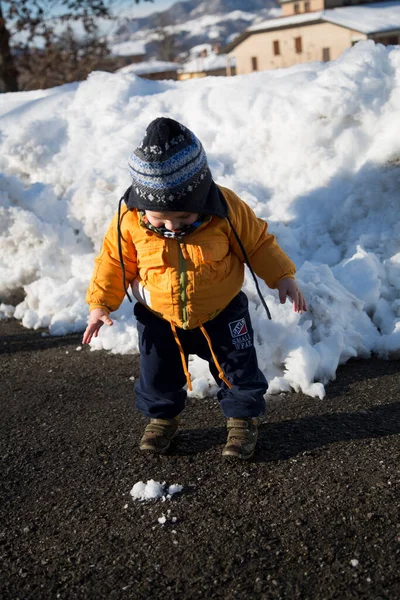 Küçük çocuk karda gülümser ve oynar. Yüksek kalite fotoğraf