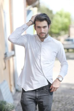 Güzel adam ortaya doğru beyaz gömlekle yürüyor. Yüksek kalite fotoğraf