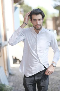 Güzel adam ortaya doğru beyaz gömlekle yürüyor. Yüksek kalite fotoğraf