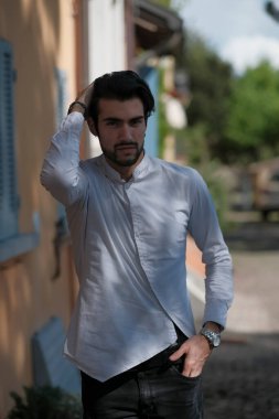 Güzel adam ortaya doğru beyaz gömlekle yürüyor. Yüksek kalite fotoğraf