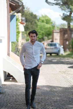Güzel adam ortaya doğru beyaz gömlekle yürüyor. Yüksek kalite fotoğraf