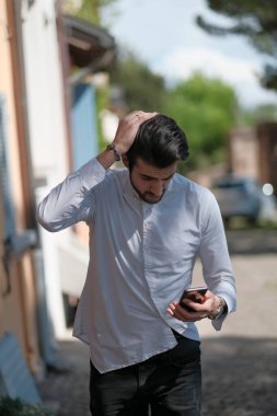 Güzel adam merkezden geçip akıllı telefona bakıyor. Yüksek kalite fotoğraf