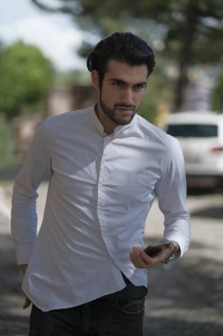 Güzel adam merkezden geçip akıllı telefona bakıyor. Yüksek kalite fotoğraf