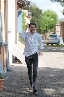 Güzel adam ortaya doğru beyaz gömlekle yürüyor. Yüksek kalite fotoğraf