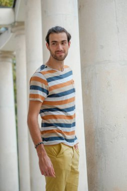 Güzel çocuk bermuda şortu ve çizgili gömleğiyle geziniyor. Yüksek kalite fotoğraf