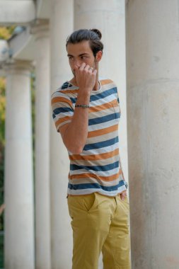 Güzel çocuk bermuda şortu ve çizgili gömleğiyle geziniyor. Yüksek kalite fotoğraf