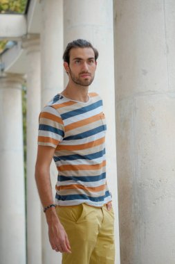 Güzel çocuk bermuda şortu ve çizgili gömleğiyle geziniyor. Yüksek kalite fotoğraf