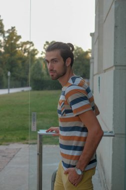 Güzel çocuk bermuda şortu ve çizgili gömleğiyle geziniyor. Yüksek kalite fotoğraf