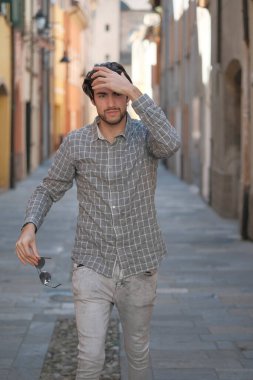 Yakışıklı, siyah saçlı İtalyan çocuk ortaçağ eski kasabasında geziniyor. Yüksek kalite fotoğraf