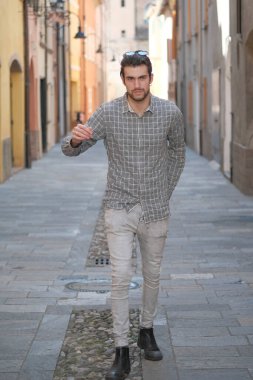 Yakışıklı, siyah saçlı İtalyan çocuk ortaçağ eski kasabasında geziniyor. Yüksek kalite fotoğraf