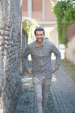 Yakışıklı, siyah saçlı İtalyan çocuk ortaçağ eski kasabasında geziniyor. Yüksek kalite fotoğraf