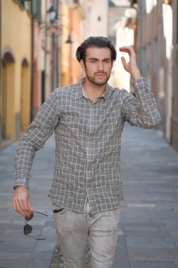 Yakışıklı, siyah saçlı İtalyan çocuk ortaçağ eski kasabasında geziniyor. Yüksek kalite fotoğraf