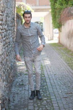 Yakışıklı, siyah saçlı İtalyan çocuk ortaçağ eski kasabasında geziniyor. Yüksek kalite fotoğraf