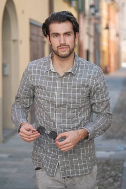 Yakışıklı, siyah saçlı İtalyan çocuk ortaçağ eski kasabasında geziniyor. Yüksek kalite fotoğraf