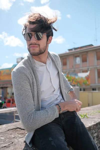 Handsome Italian Dark Haired Guy Jacket Sitting Low Wall Sunny — стоковое фото