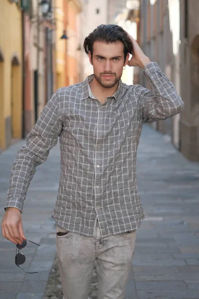 Yakışıklı, siyah saçlı İtalyan çocuk ortaçağ eski kasabasında geziniyor. Yüksek kalite fotoğraf