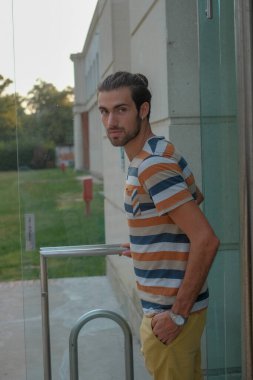 Güzel çocuk bermuda şortu ve çizgili gömleğiyle geziniyor. Yüksek kalite fotoğraf