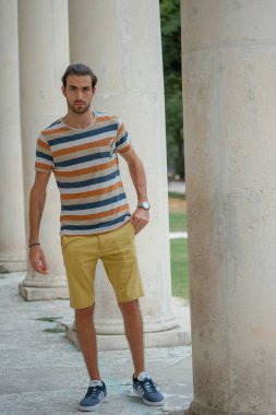 Güzel çocuk bermuda şortu ve çizgili gömleğiyle geziniyor. Yüksek kalite fotoğraf