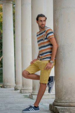 Güzel çocuk bermuda şortu ve çizgili gömleğiyle geziniyor. Yüksek kalite fotoğraf