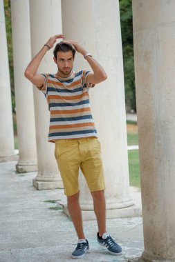 Güzel çocuk bermuda şortu ve çizgili gömleğiyle geziniyor. Yüksek kalite fotoğraf