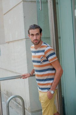 Güzel çocuk bermuda şortu ve çizgili gömleğiyle geziniyor. Yüksek kalite fotoğraf