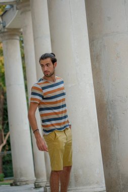 Güzel çocuk bermuda şortu ve çizgili gömleğiyle geziniyor. Yüksek kalite fotoğraf