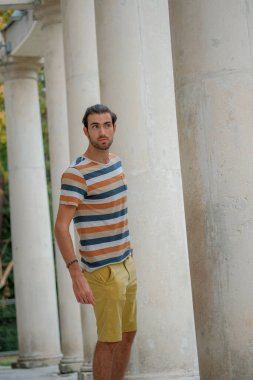 Güzel çocuk bermuda şortu ve çizgili gömleğiyle geziniyor. Yüksek kalite fotoğraf