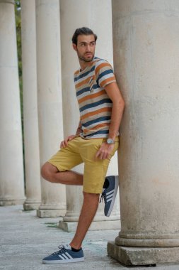 Güzel çocuk bermuda şortu ve çizgili gömleğiyle geziniyor. Yüksek kalite fotoğraf