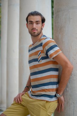 Güzel çocuk bermuda şortu ve çizgili gömleğiyle geziniyor. Yüksek kalite fotoğraf